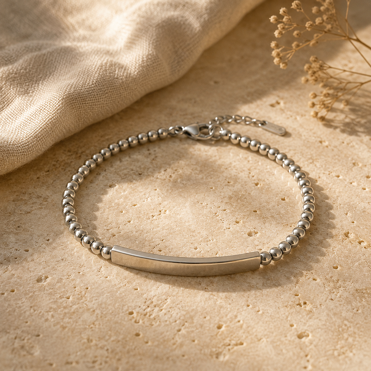 Silver beaded bracelet with an engraved bar on warm stone