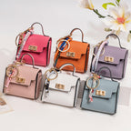 Mini Luxury Bag Keychain Charm — palm-sized faux leather handbag charm with gold hardware and scarf ribbon